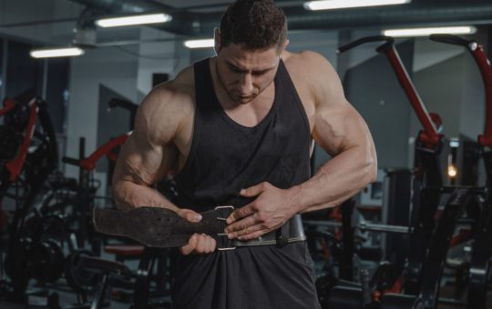 bodybuilder putting on lifting belt